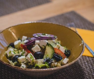 A delicious Greek salad featuring feta cheese, olives, and fresh vegetables in a rustic bowl.
